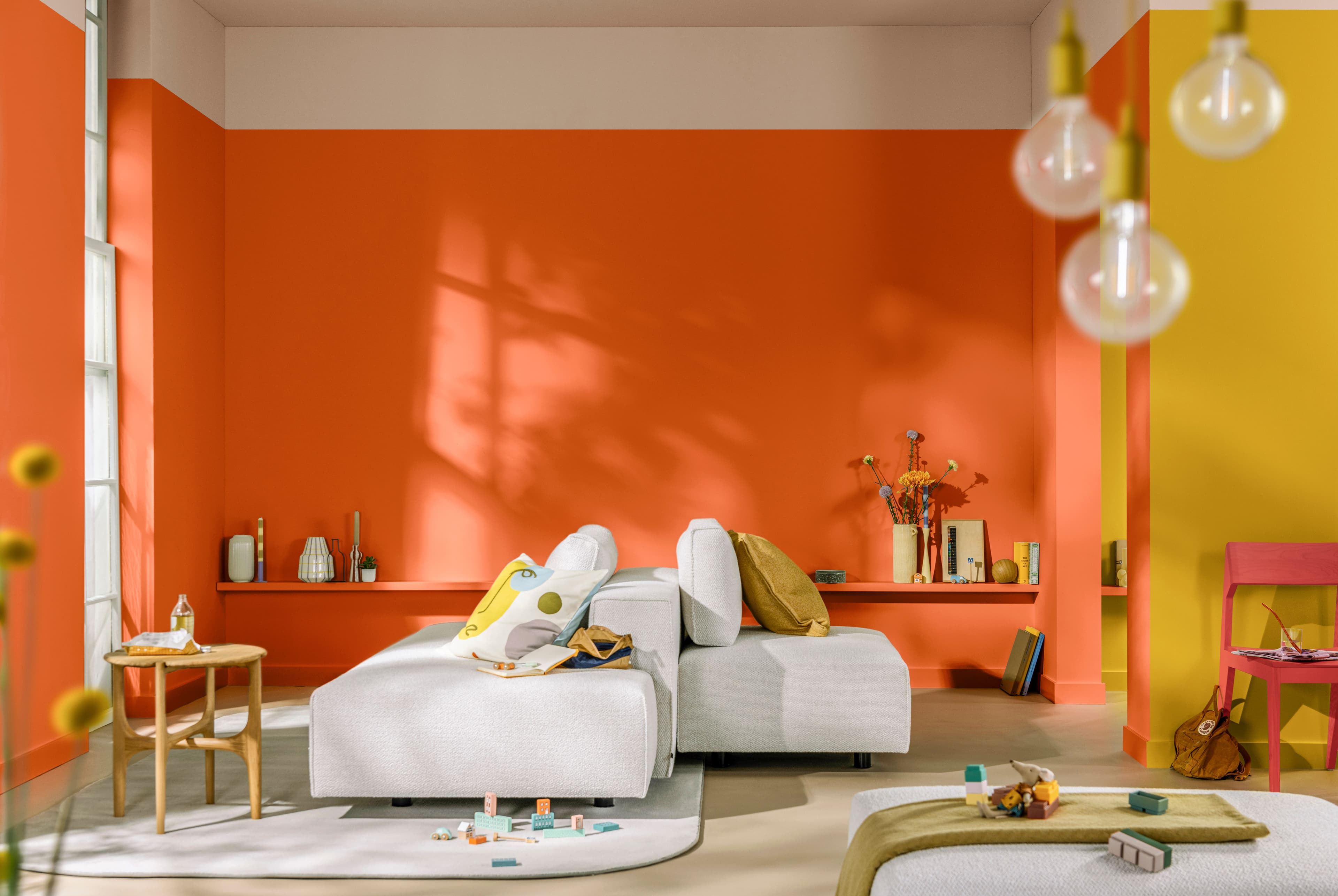 A bright orange living room with bold coloured furnishings.
