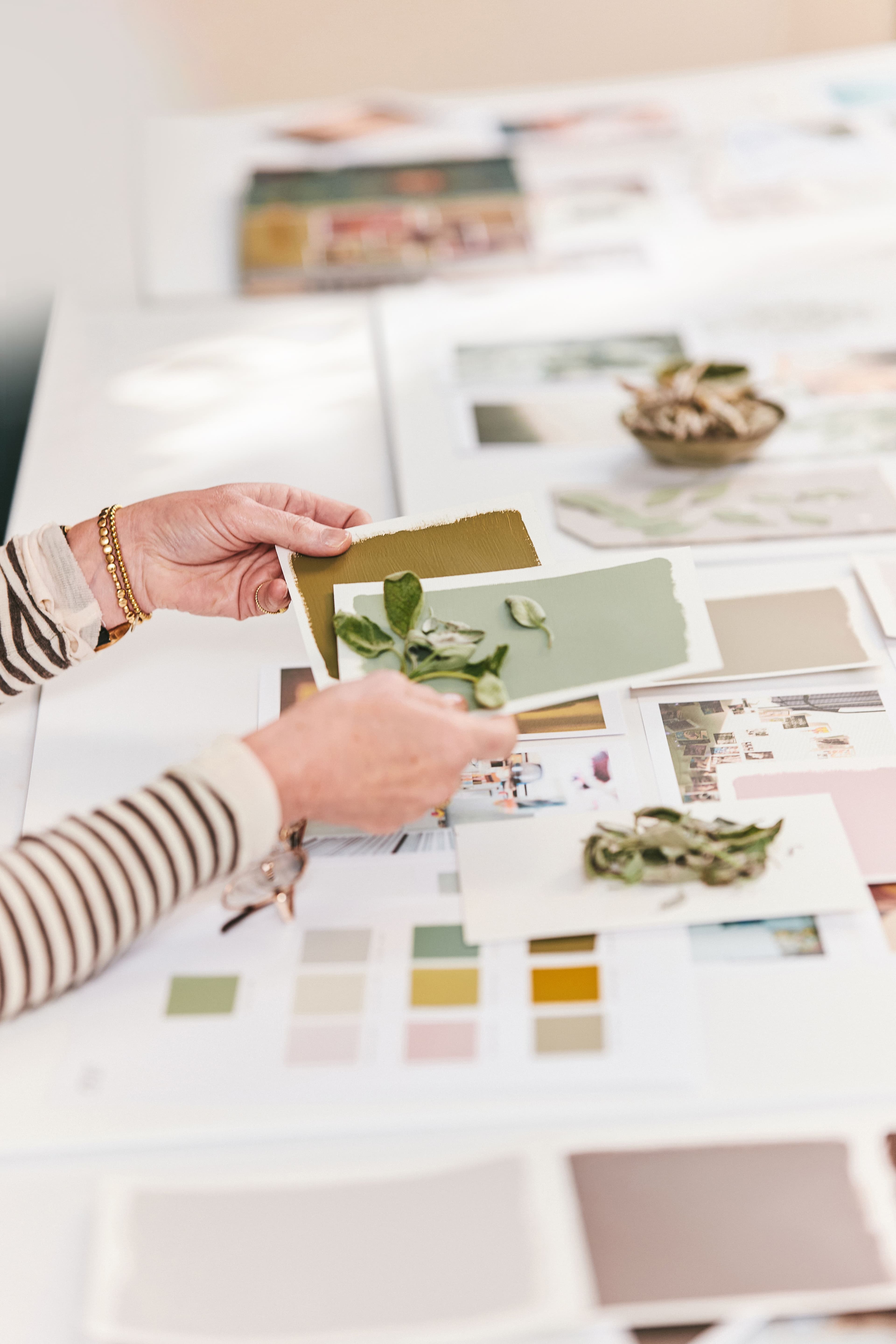 Somebody looking through swatches of colour on a table