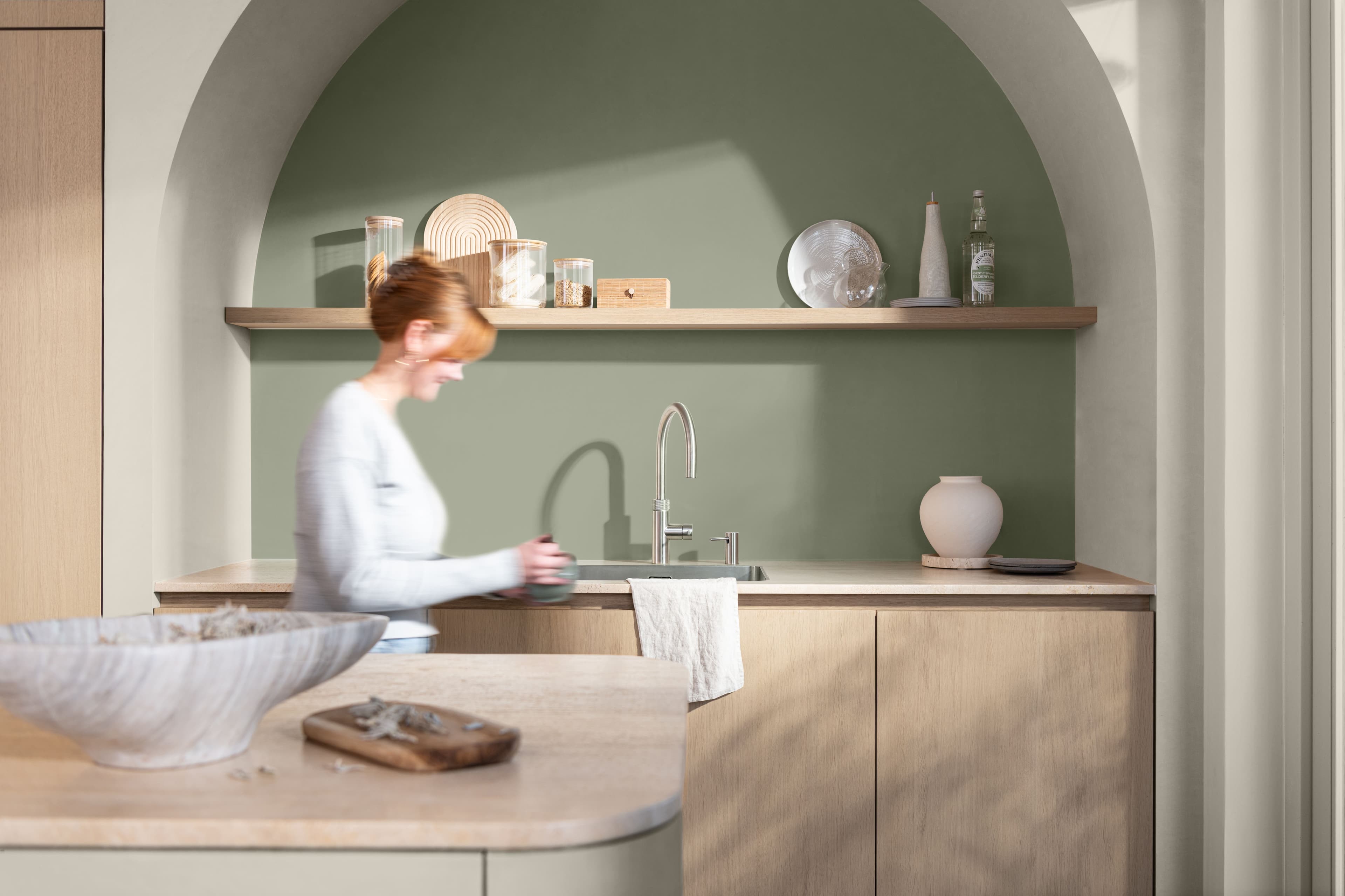 Kitchen with green feature wall inside an arch
