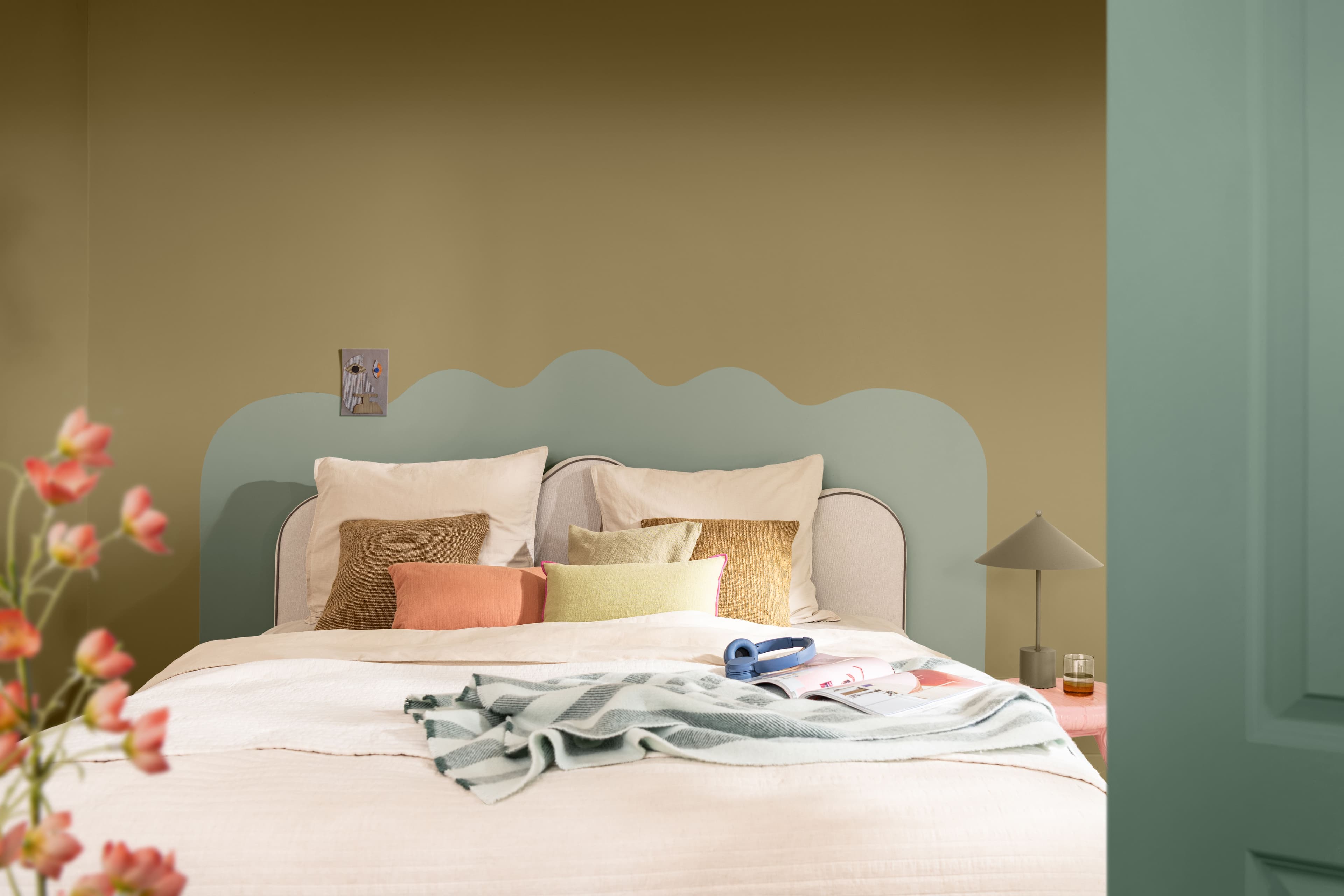 Bedroom with ochre walls and a painted green headboard