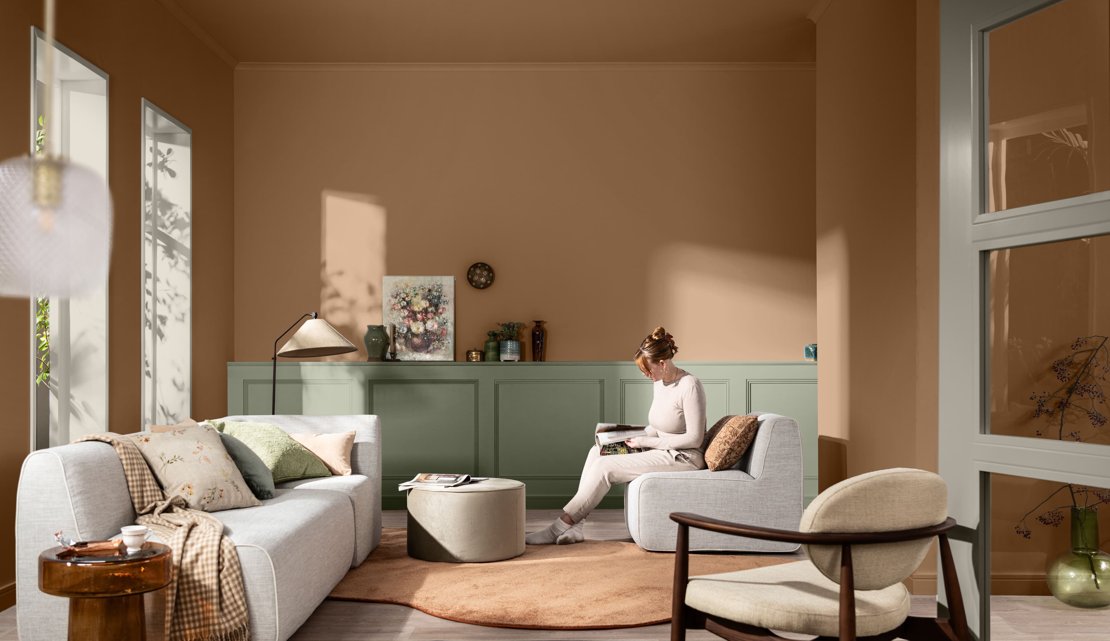 Living room with pale terracotta walls, a pale green cabinet and a colour palette on the right-hand side