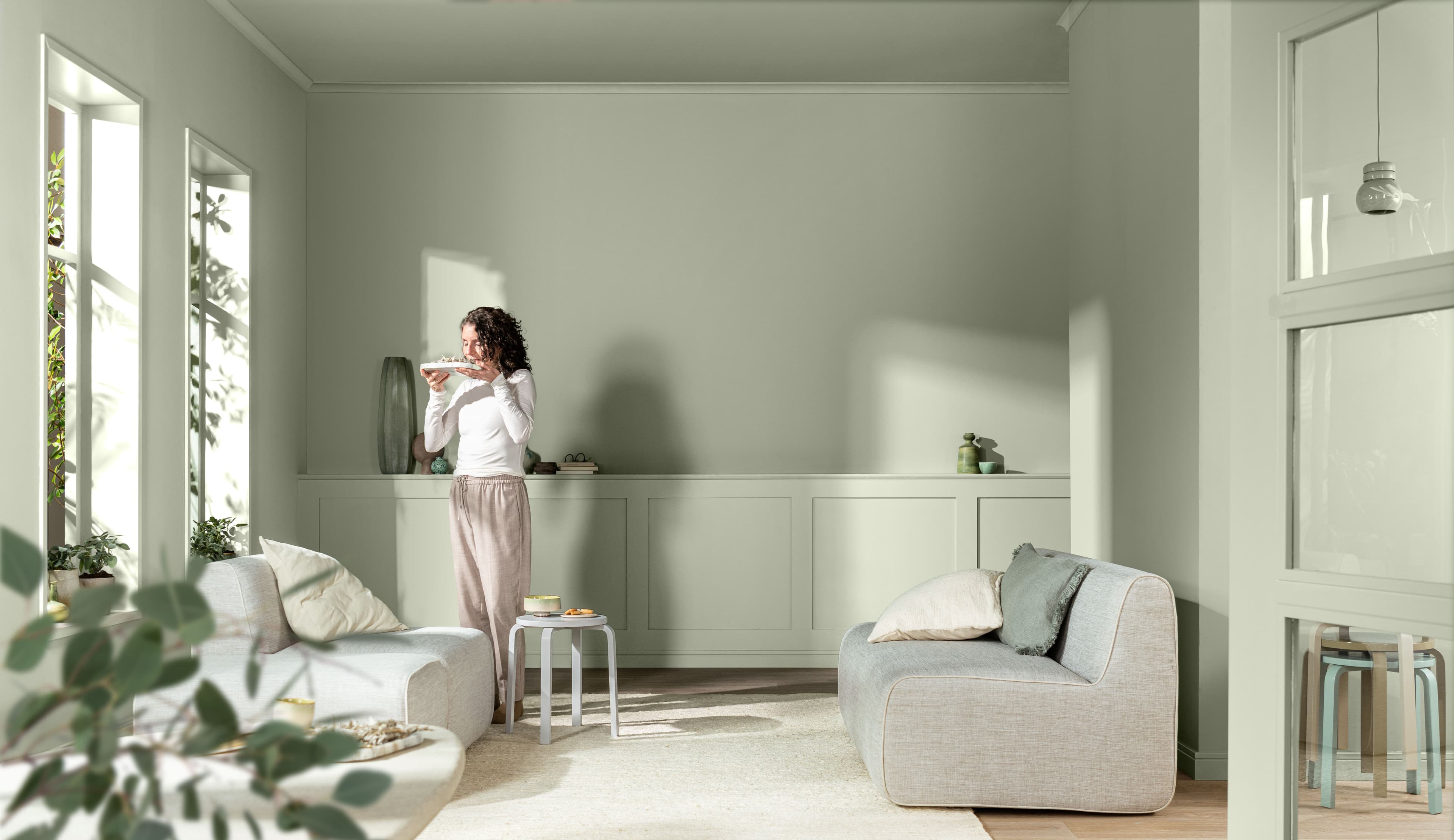 Living room with walls and furniture painted in soft green and a colour palette on the right-hand side