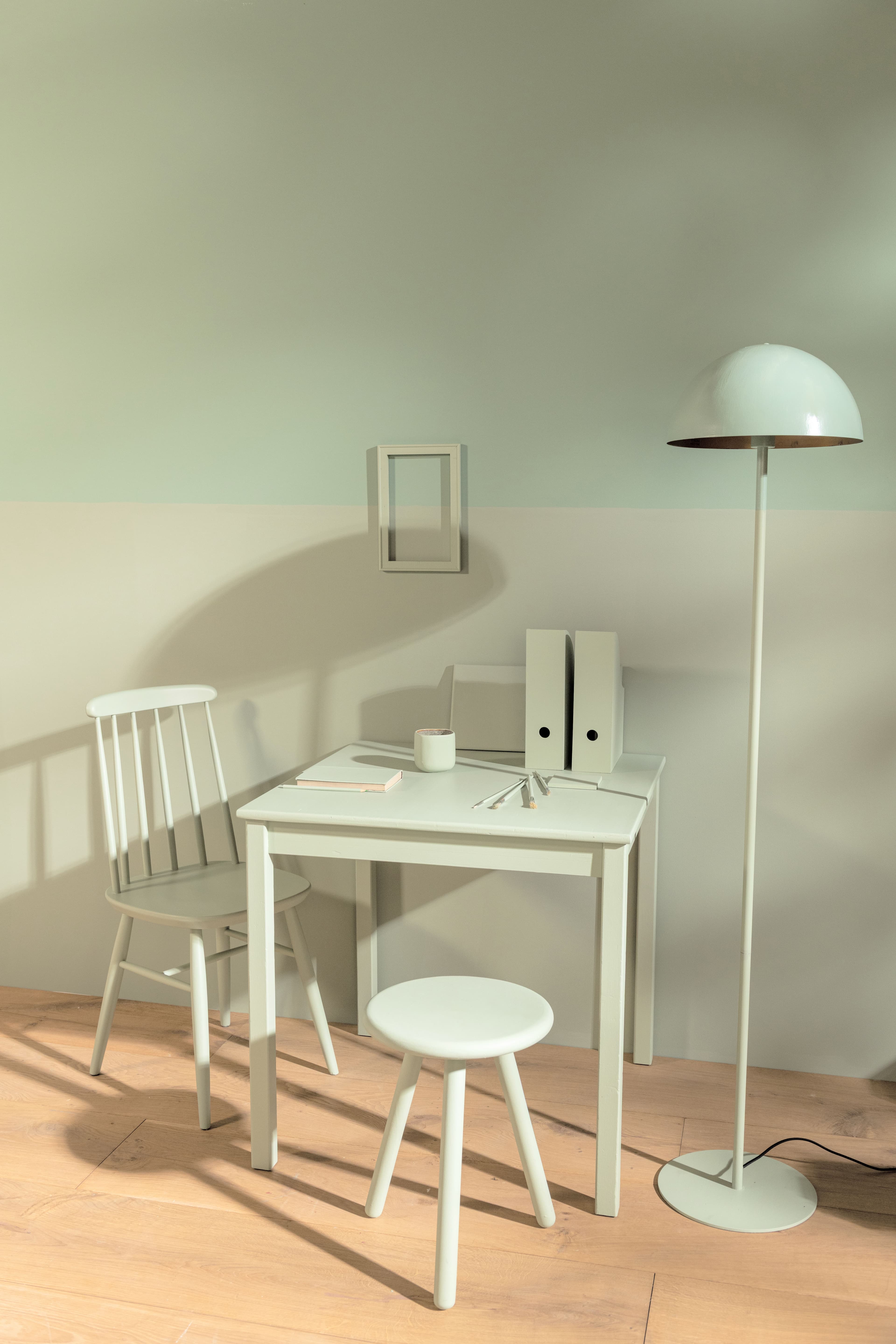 Workspace with green wall painted in two colours, with furniture also painted in green.